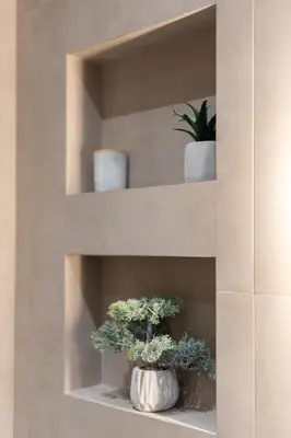 two potted plants sitting on shelves in a room at 