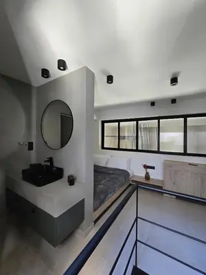 a bedroom with a bed and a sink and a mirror at Spacious Minimalistic Loft ,5 minutes walk to Metro in Athens