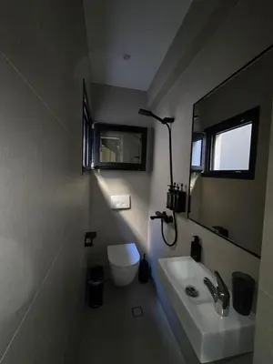 a bathroom with a sink and a toilet and a mirror at Spacious Minimalistic Loft ,5 minutes walk to Metro in Athens