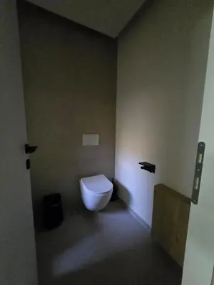a bathroom with a white toilet in a room at Spacious Minimalistic Loft ,5 minutes walk to Metro in Athens