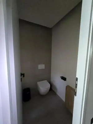 a bathroom with a white toilet in a room at Spacious Minimalistic Loft ,5 minutes walk to Metro in Athens