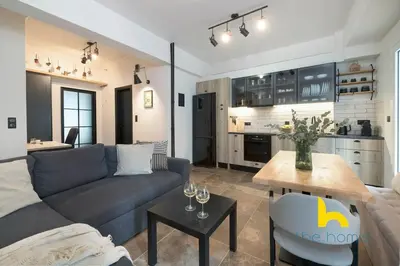 a living room with a couch and a table and a kitchen at Kaimaki in Athens