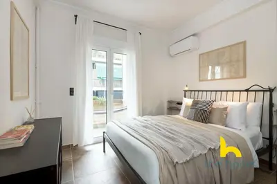 a bedroom with a bed and a desk and a window at Kaimaki in Athens
