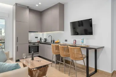 a kitchen with a table and chairs in a living room at Rizes Suites Metro Dafni in Athens