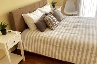 a bedroom with a bed with pillows and a night stand at Cozy Athenian 2BD Apt Top Floor Panoramic View in Athens