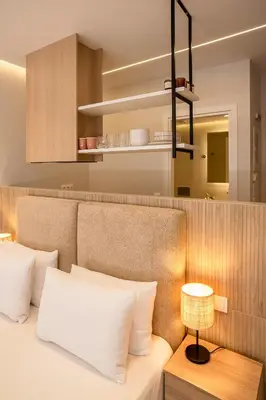 a bed with white pillows and a table with a lamp at Urban Athens Gem in Athens