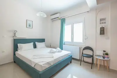 a bedroom with a blue bed and a chair at Cozy Acropolis Studio in the heart of Athens in Athens