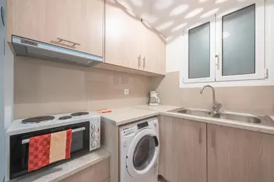 a kitchen with a washing machine and a sink at Cozy Acropolis Studio in the heart of Athens in Athens