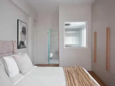 a white bedroom with a bed and a mirror at Sleek & Stylish 2 bd apt with Parthenon view in Athens