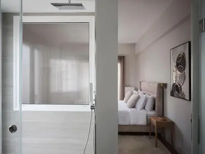 a bedroom with a bed and a glass door leading to a shower at Sleek & Stylish 2 bd apt with Parthenon view in Athens