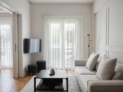 a white living room with a couch and a table at Sleek & Stylish 2 bd apt with Parthenon view in Athens