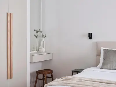 a bedroom with a bed and a stool next to it at Sleek & Stylish 2 bd apt with Parthenon view in Athens