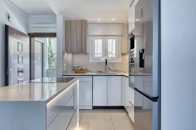 a kitchen with white cabinets and a counter top at Luxury Beachfront Paradise in Athens Rivieria Kavouri Vouliagmeni in Athens