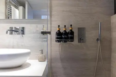 a bathroom with a shower with wine bottles on the wall at Luxury Beachfront Paradise in Athens Rivieria Kavouri Vouliagmeni in Athens