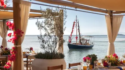 a boat in the water with a table with flowers at Luxury Beachfront Paradise in Athens Rivieria Kavouri Vouliagmeni in Athens