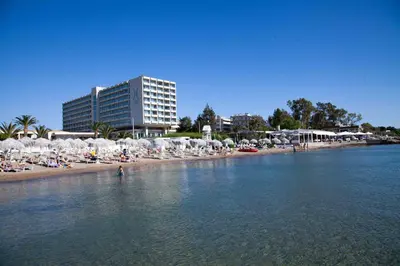 a beach with chairs and umbrellas and people in the water at Luxury Beachfront Paradise in Athens Rivieria Kavouri Vouliagmeni in Athens