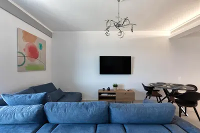 a living room with a blue couch and a table at Luxury Beachfront Paradise in Athens Rivieria Kavouri Vouliagmeni in Athens