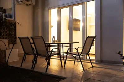 a glass table and four chairs in a room at South Glyfada Downtown49 Apartment in Athens