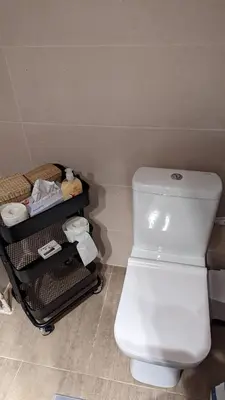 a bathroom with a white toilet and a cart at Acropolis View Condo, perfect location! in Piraeus