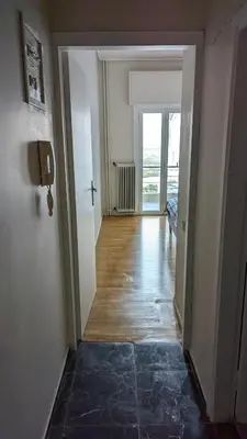an empty room with a hallway with a door to a room with a window at Acropolis View Condo, perfect location! in Piraeus