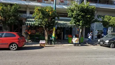 a red car parked in front of a store at Acropolis View Condo, perfect location! in Piraeus