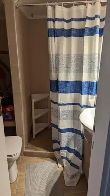 a bathroom with a shower curtain and a toilet at Acropolis View Condo, perfect location! in Piraeus