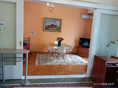 a living room with a table and chairs at Neos kosmos Filimon in Athens