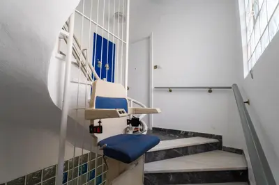 a hospital room with a blue chair in a waiting room at Neos kosmos Filimon in Athens