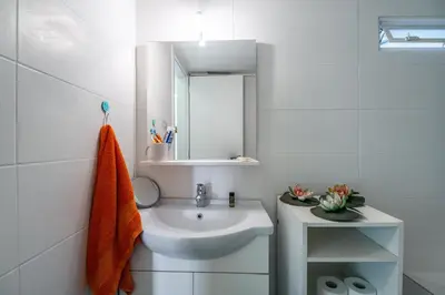 a white bathroom with a sink and a mirror at Neos kosmos Filimon in Athens