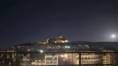 a view of a mountain at night at Lycabettus View Kaniggos in Athens