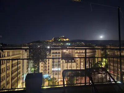 a view of a city at night from a balcony at Lycabettus View Kaniggos in Athens