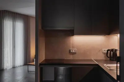 a kitchen with black cabinets and a counter top at Thissio Acropolis Historic Flat 1 in Athens