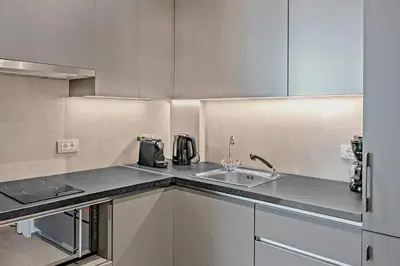 a kitchen with white cabinets and a sink at Thissio Acropolis Historic Flat 1 in Athens