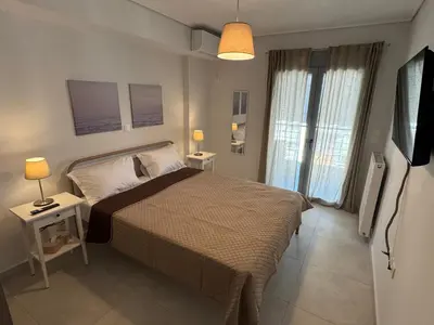 a bedroom with a bed and a television in it at Central Apartment with private parking in Athens
