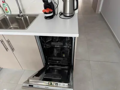 an open dishwasher in a kitchen next to a sink at Central Apartment with private parking in Athens