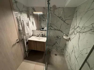 a bathroom with a sink and a glass shower at Central Apartment with private parking in Athens