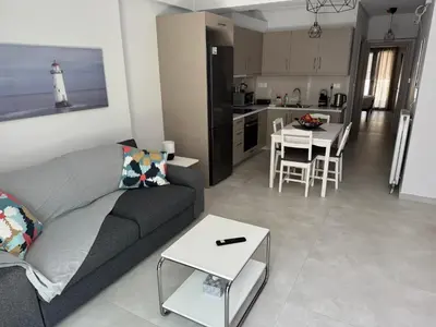 a living room and kitchen with a couch and a table at Central Apartment with private parking in Athens