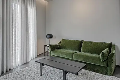 a living room with a green couch and a table at Thissio Acropolis Historic Flat 2 in Athens
