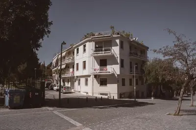 a white building with a balcony on a street at Thissio Acropolis Historic Flat 2 in Athens