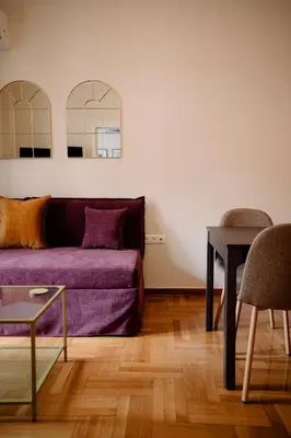 a living room with a purple couch and a table at Acanthus Art Deco Retreat 250 from Metro & Archaeology Museum in Athens