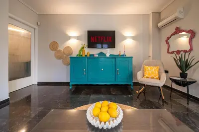 a living room with a blue cabinet with oranges on a table at Comfy and calm apartment near the beach in Athens