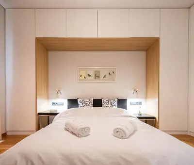 a bedroom with a large white bed with two towels on it at Comfy and calm apartment near the beach in Athens