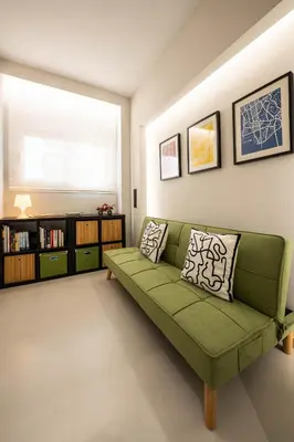 a living room with a green couch and a window at Comfy and calm apartment near the beach in Athens