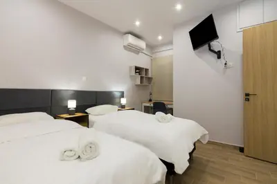 two beds in a room with a tv on the wall at Luxury Apartment for 5 Ppl in the Center of Athens in Athens