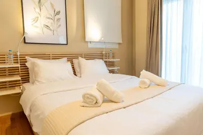 a bedroom with a large white bed with towels on it at Acropolis Central Living in Athens