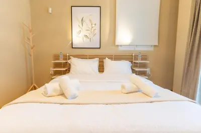 a bedroom with a white bed with two pillows at Acropolis Central Living in Athens