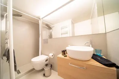 a bathroom with a sink and a toilet and a mirror at Acropolis Central Living in Athens