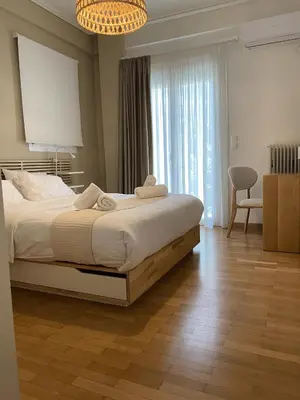 a bedroom with a large bed and a chandelier at Acropolis Central Living in Athens