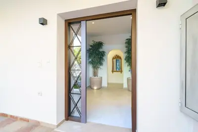 an open door into a hallway with a plant at BAMBOO Athens Villa in Athens