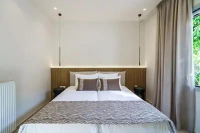 a bedroom with a large white bed with two pillows at BAMBOO Athens Villa in Athens